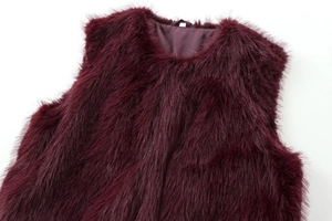 Détail du gilet en fausse fourrure bordeaux montrant la texture douce et la doublure en soie