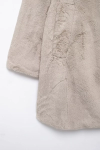 Close-up of soft light gray faux fur texture and sleeve detail on women's winter coat