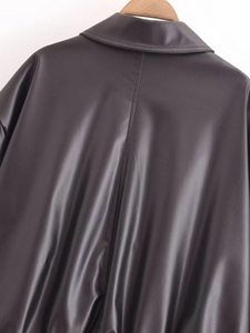 Detailansicht der Rückseite einer schwarzen Kunstlederjacke mit vertikaler Naht und Textur