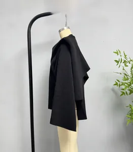 Detailed texture of black knit poncho sweater showing thick ribbed material and high quality