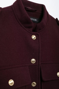 Detail of burgundy wool coat showing stand collar and textured gold metal buttons