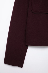 Close-up of wine red wool coat fabric texture and professional stitching on pocket area
