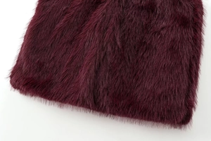 Gros plan sur la fausse fourrure bordeaux douce montrant une texture de luxe dense