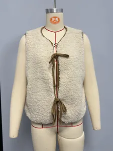 Detail of cream fleece vest featuring brown fabric trim and elegant ribbon tie closures