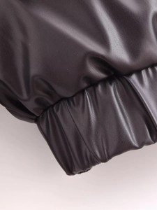 Makro-Detail der schwarzen PU-Kunstlederjacke mit Litschi-Struktur und elastischem Saum
