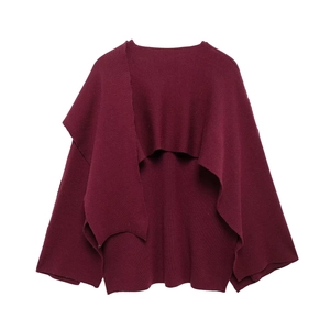Detail of burgundy knit poncho showing soft fabric texture and irregular draped open front