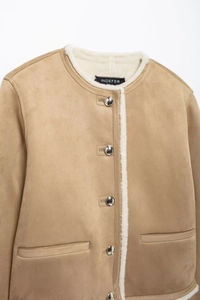 Détail de la veste en daim camel avec doublure en fausse fourrure blanche et boutons argent
