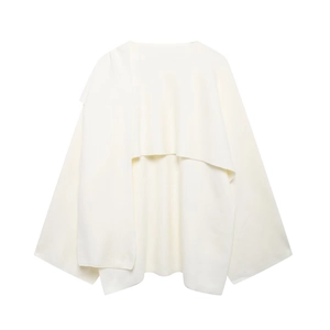 Detail of white asymmetric knitted shawl with wide bell sleeves and fluid draped silhouette