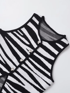 Detail view of knitted vest featuring zebra stripes and silver metal buttons