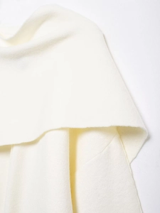 Close-up detail of soft white knitted fabric texture for woman fashion poncho sweater