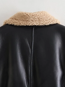 Détail d'un gilet en cuir noir avec col en peau de mouton beige et couture dorsale