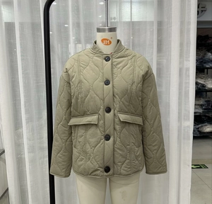 Detail of wave quilted jacket showing khaki ribbed collar and large button closure