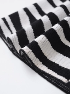 Close-up of black and white striped knit fabric showing detailed texture and soft yarn