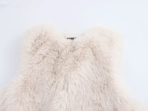 Close-up of the beige faux fur texture and neckline detail of the winter vest
