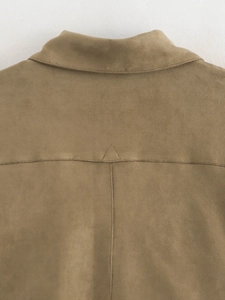 Detail of double-needle stitching and triangle reinforcement on khaki suede jacket back