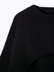 Detail of black textured knit fabric on a stylish cape-style sweater jacket