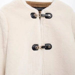 Chic cream faux fur jacket with brown suede collar and stylish metal buckle closures