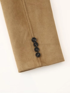Close-up of camel suede jacket cuff featuring four marbled black buttons and fine stitching