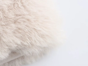 Close-up of premium cream faux fur material showing soft texture and glossy fibers