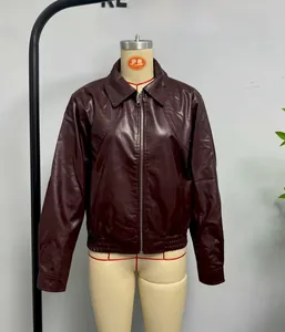 Detail of reddish-brown PU leather jacket featuring zippered front and ribbed hemline