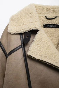 Détail d'une veste en suédine avec doublure en peau lainée et fermeture éclair en métal
