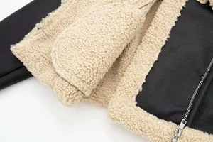 Detailed close-up of high-quality black leather jacket with soft white sherpa fur lining