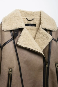 Détail de la veste en daim marron avec col en peau de mouton blanche et fermeture éclair