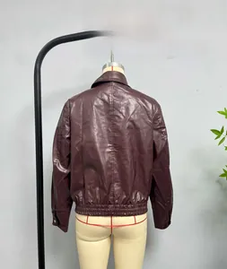 Detail of burgundy leather jacket with elastic hem and button cuffs on mannequin