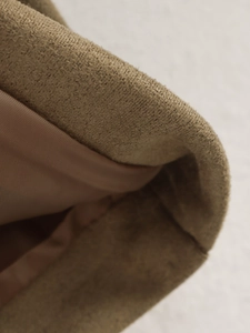 Close-up of khaki textured wool fabric and smooth brown satin lining on a jacket