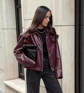 Detail of burgundy faux leather jacket with zip closure and lapel collar for women