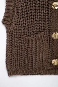 Detail of dark brown chunky knit vest with honeycomb texture and gold metal buttons