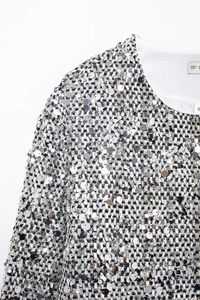 Dettaglio delle paillettes argento e della trama in tweed su una giacca elegante