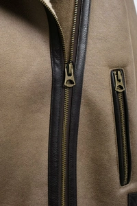 Détail de la veste en peau de mouton avec texture suédée, passepoil en cuir et zip métal