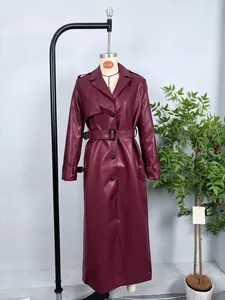 Detailed close-up of a burgundy faux leather trench coat with lapels and belted waist