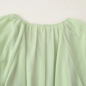 Elegant light green tiered chiffon dress with ruffled neckline and pleated texture details