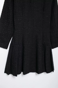 Détail de la robe mini en tweed noir avec fils pailletés argentés et ourlet plissé évasé