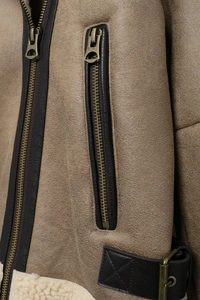 Détails de la doublure en fausse fourrure et du cuir texturé sur un blouson aviateur zippé