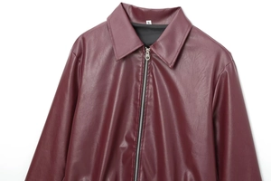 Detailed view of the smooth wine red faux leather texture and size label on the collar
