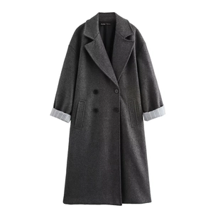 Detail of dark grey wool coat featuring double-breasted buttons and striped sleeve lining