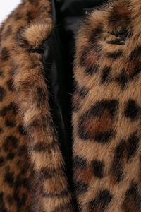 Macro detail of dense leopard print faux fur texture with smooth black inner lining