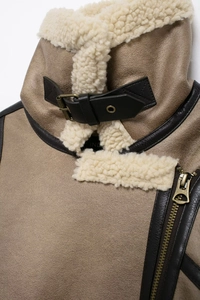 Détail d'une veste aviateur beige avec doublure en peau de mouton et boucle en métal