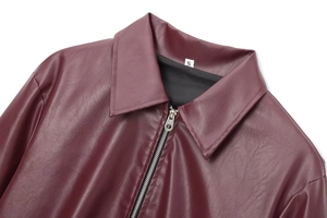 Detailed close-up of a burgundy leather jacket collar with silver zipper and size S label