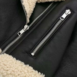 Women's black shearling biker jacket with cream faux fur lining and silver zippers