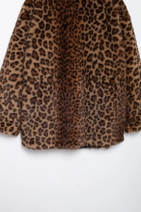 Detail of leopard print faux fur coat showing texture and soft hemline finish