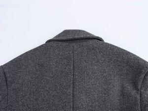Close-up of gray wool double-breasted coat showing textured fabric and collar stitching