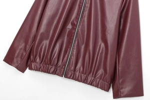 Detail view of the deep wine red faux leather jacket featuring elastic hem and silver zipper