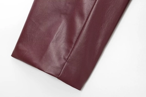 Detail shot of burgundy faux leather jacket showing premium grain texture and stitching