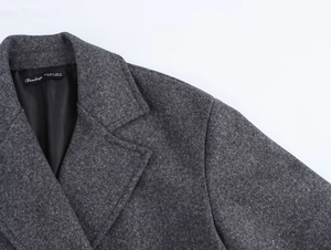 Detail of dark grey wool coat featuring a tailored lapel and premium brand woven label