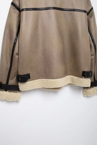 Détail d'une veste en suédine avec doublure en peau de mouton et boucles d'ourlet réglables