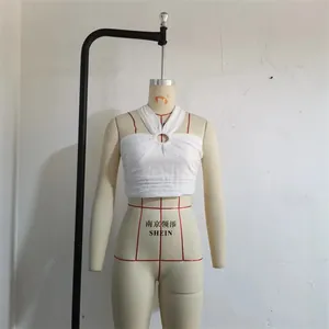 Detail view of white halter crop top featuring a central ring connector and ruched fabric